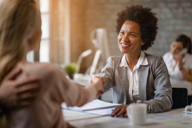 woman shaking hands in office